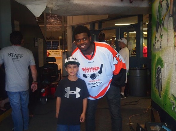 Boston Bruin prospect, goaltender Malcolm Subban, poses with fan Sebastian 